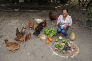 Eine Kleinbäuerin aus Kolumbien zeigt stolz ihre Nahrungsmittel, die sie aus bäuerlichem Saatgut produziert.